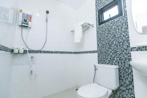 een badkamer met een toilet, een douche en een wastafel bij The Gun Hotel in Surin