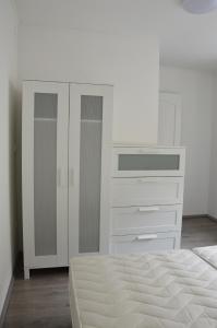 a white bedroom with a bed and a dresser at Haus Im Zentrum R 6 Schlafzimmer 10 Pax in Szombathely