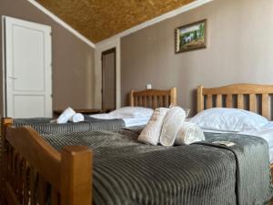two beds with white pillows on them in a room at Hotel Dari in Stepantsminda