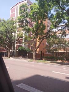 an empty street in front of a tall building at Comfy spacious apartment in Pretoria