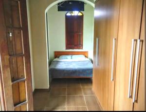 a small bedroom with a bed in a room at Casa Colonial com lareira in São Lourenço
