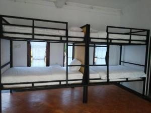 two bunk beds in a room with white sheets at Bali Telaga Hati Yoga Healty And Retreat Center in Sanur