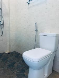 a bathroom with a white toilet and a shower at Center Point Villa Unawatuna in Unawatuna