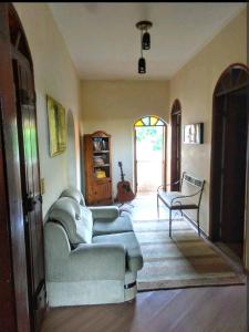 a living room with a couch and a chair at Casa Colonial com lareira in São Lourenço +5 photos