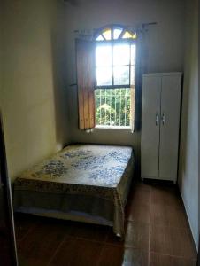 een kleine slaapkamer met een bed en een raam bij Casa Colonial in São Lourenço