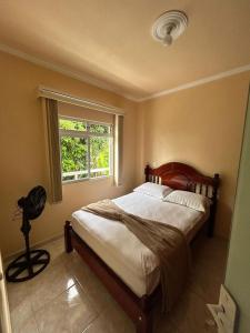 a bedroom with a large bed with a window at Acomodação vó Nilton in Governador Celso Ramos