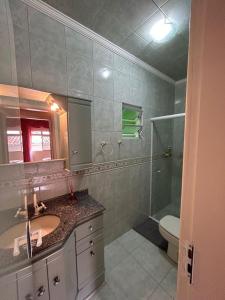 a bathroom with a sink and a shower and a toilet at Acomodação vó Nilton in Governador Celso Ramos