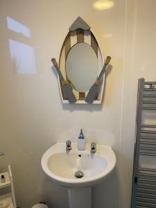 a bathroom with a white sink and a mirror at Lighthouse View, one min from harbour & beach in Scarborough