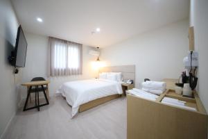 a hotel room with a bed and a television at HARU Hotel in Changwon