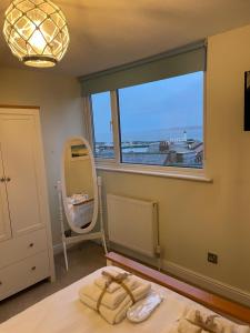 a bedroom with a large window and a mirror at Lighthouse View, one min from harbour & beach in Scarborough