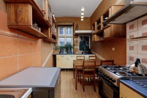 a kitchen with wooden cabinets and a stove top oven at Stare Miasto Krupnicza in Wrocław