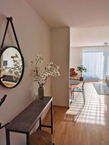 a living room with a table and a mirror at Modern Apartments Vienna in Vienna