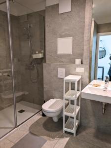a bathroom with a shower and a toilet and a sink at Modern Apartments Vienna in Vienna