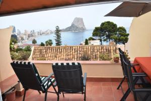 uma varanda com mesa e cadeiras e vista para o oceano em Apartamento Castillo mit Meeresblick em Calpe