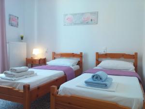 2 Betten in einem Zimmer mit Handtüchern darauf in der Unterkunft Skiathos home with the best view in Skiathos-Stadt