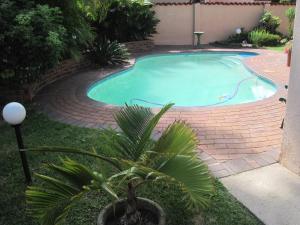 a swimming pool with a brick path around it at Swallows Nest B&B in Margate