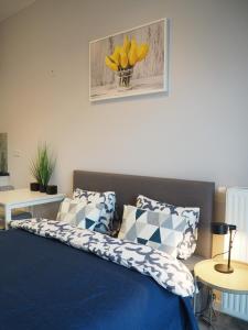 um quarto com uma cama azul com flores amarelas em MoonApart A2 em Varsóvia