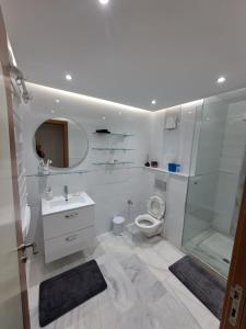 La salle de bains blanche est pourvue d'une douche et de toilettes. dans l'établissement Appart Riad garden, à Marrakech