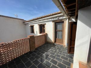 Un balcón de una casa con puerta de madera en Casas rurales los castaños, en Jerez del Marquesado