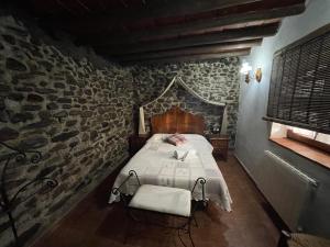 1 dormitorio con 1 cama en una pared de piedra en Casas rurales los castaños, en Jerez del Marquesado