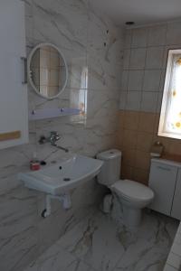 a bathroom with a sink and a toilet and a mirror at Domek Białka Tatrzańska in Białka Tatrzańska