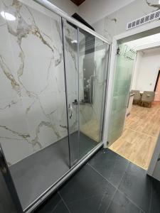 une cabine de douche en verre avec un mur en marbre dans l'établissement Appartement 2 chambre luxueuse à jette, à Bruxelles