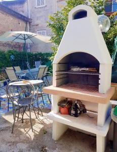 um forno de pizza ao ar livre com cadeiras e um guarda-sol em Casa Vacanze Smeralda Amalfi Coast em Vietri