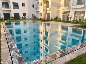 a swimming pool in front of a building at Élégance en 40 mètres Nouaceur in Nouaceur