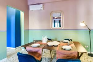 una sala da pranzo con tavolo, sedie e specchio di Sweet Inn - Ariberto a Milano