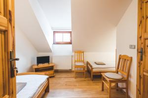 a room with two beds and a desk and a tv at Pension Krumau in Český Krumlov