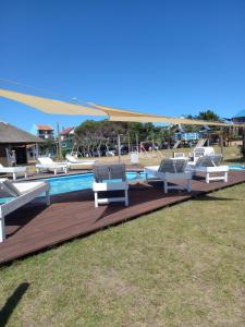 a group of lounge chairs sitting next to a pool at Cabañas Dunas del Diablo in Punta Del Diablo