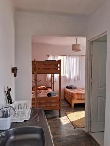 een keuken met een wastafel en een slaapkamer met een stapelbed bij Cabañas de Punta Negra in Punta Negra