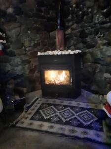 a fireplace in a stone building with a fire at Family Hotel Maia - Cемейная гостиница Майя in Dashbashi