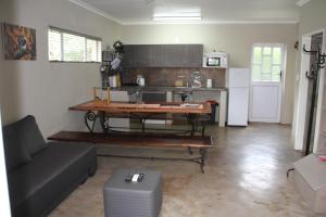 sala de estar con sofá, mesa y nevera en Comfortable cottage in Big 5 Game Reserve en Dinokeng Game Reserve