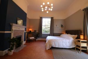 a bedroom with a bed and a fireplace and a chandelier at Eastfield in Liverpool