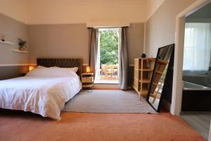 1 dormitorio con cama, bañera y ventana en Eastfield, en Liverpool