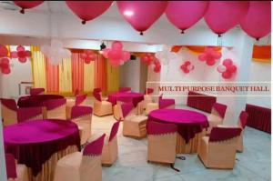 Habitación con mesas rosas, sillas y globos en Boutique Hotel vivaan suites en Noida