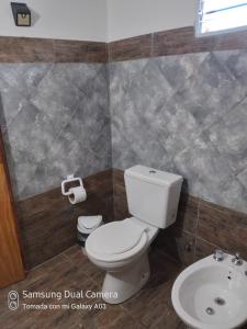 a bathroom with a toilet and a sink at Nancy's Residencias in Santa Rosa de Calamuchita