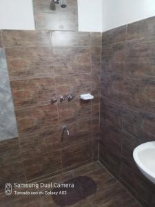 een badkamer met een douche, een toilet en een wastafel bij Nancy's Residencias in Santa Rosa de Calamuchita