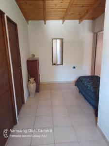 a room with a bed and a mirror on the wall at Nancy's Residencias in Santa Rosa de Calamuchita