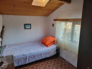 a bedroom with a bed with an orange pillow on it at Вила Рени in Varna City