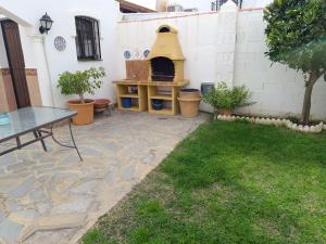 un patio con una mesa y un horno de pizza en Chalet junto al mar con jardín privado, en La Cala de Mijas