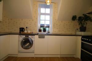 a kitchen with a washing machine and a window at Eastfield in Liverpool