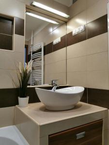łazienka z umywalką i dużym lustrem w obiekcie Római 1 w mieście Dunaújváros