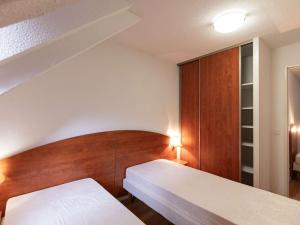 1 dormitorio con 2 camas y cabecero de madera en Appartement La Mongie, 3 pièces, 7 personnes - FR-1-404-248, en Bagnères-de-Bigorre