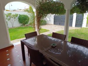 - une table et des chaises sur une terrasse couverte offrant une vue sur la cour dans l'établissement Chalet junto al mar con jardín privado, à La Cala de Mijas