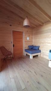 Habitación con 1 cama y 1 silla en una cabaña en Cabañas Orca Lodge Norte vista panoramica, en Curanipe