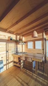 una cucina con isola in una camera con pareti in legno di Cabaña Orca Lodge Norte frente al mar en Curanipe, Desconéctate para reconectar a Curanipe