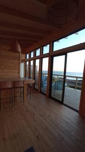 Habitación grande con mesa y algunas ventanas. en Cabañas Orca Lodge Norte vista panoramica, en Curanipe