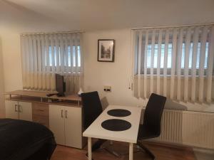 Zimmer mit einem Schreibtisch und einem Tisch mit Stühlen in der Unterkunft Bonitoapartamento-Vienna in Wien
